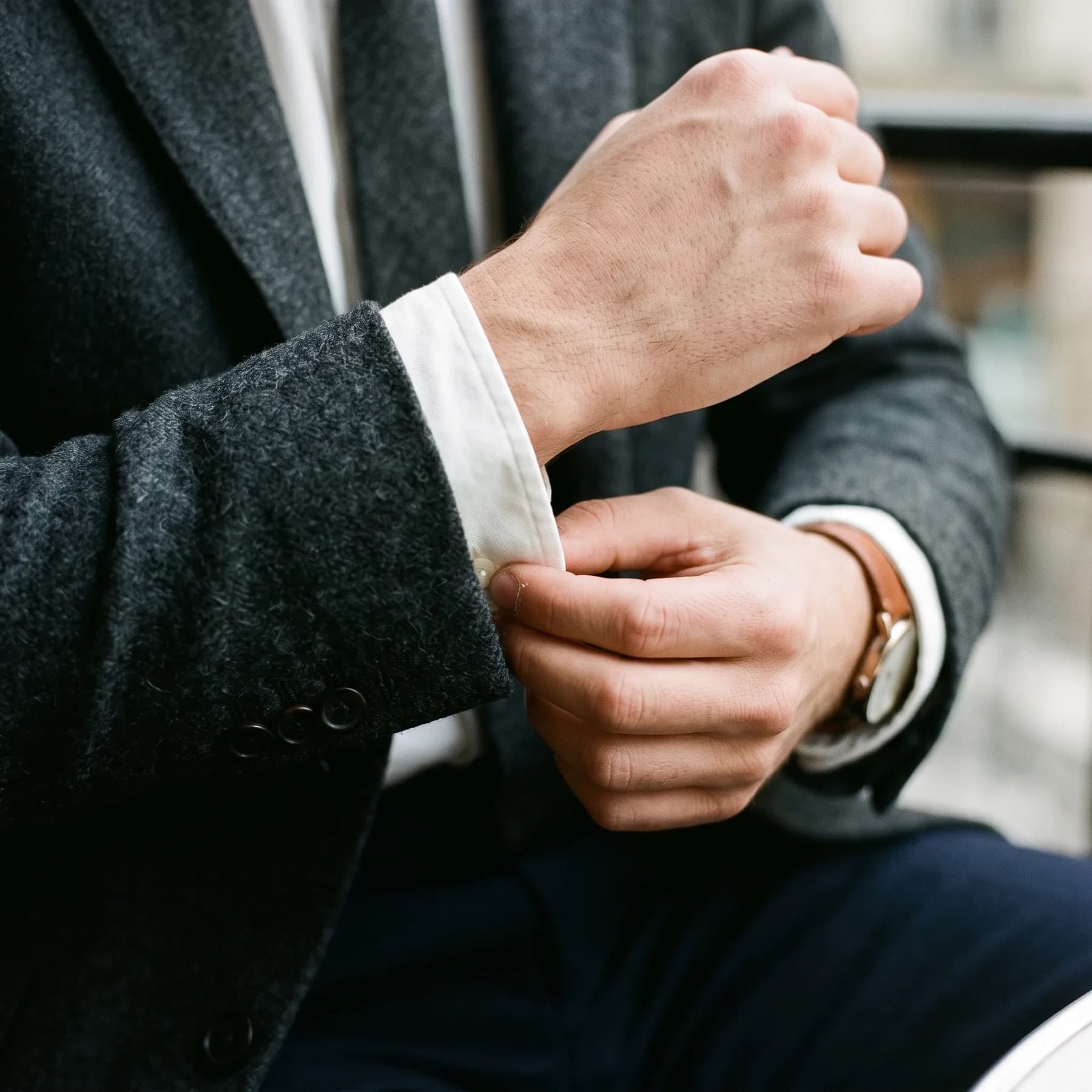 Poignet de chemise blanche sous un blazer en flanelle anthracite